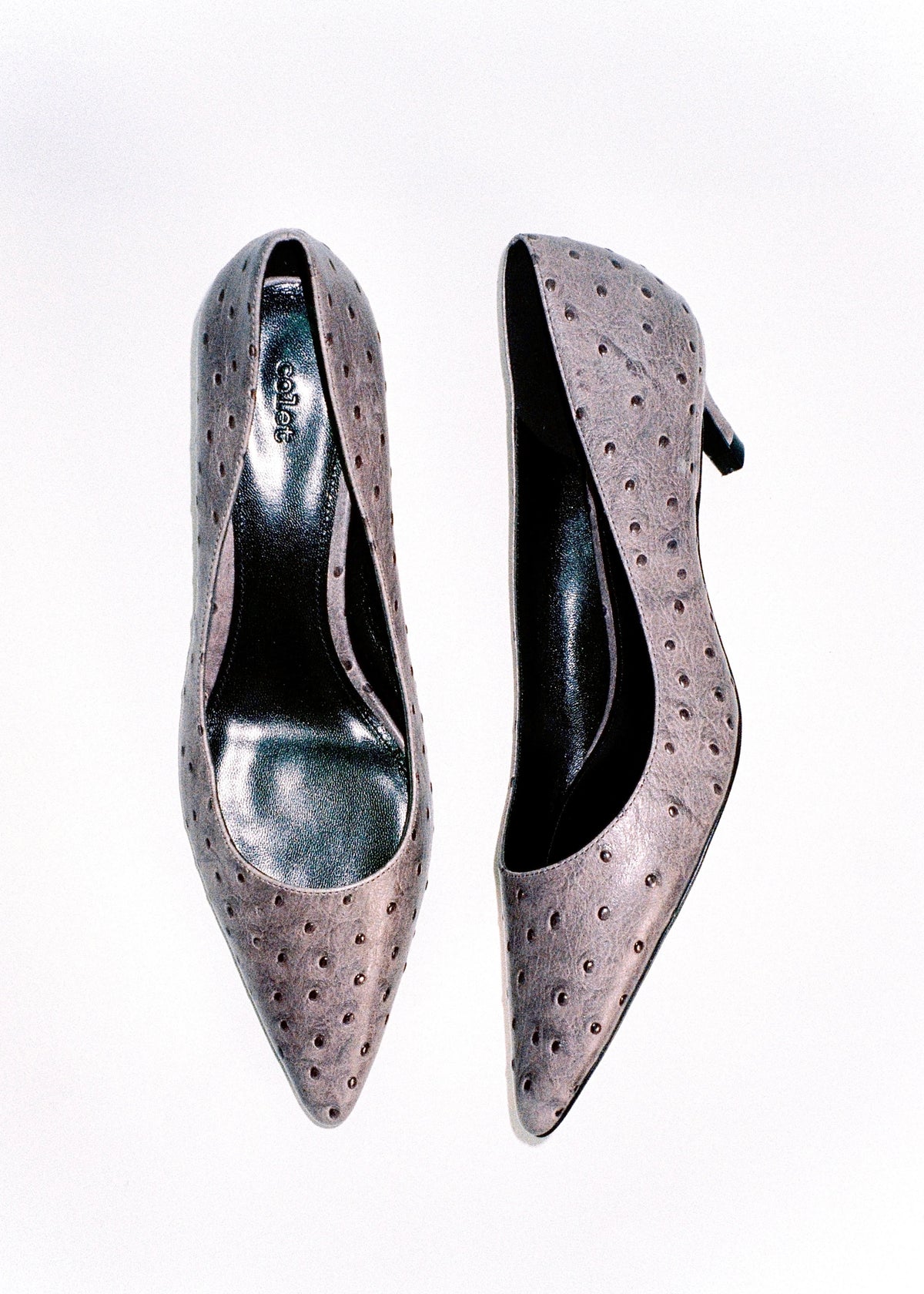 Pair of pale pink pointed-toe pumps with perforated uppers.