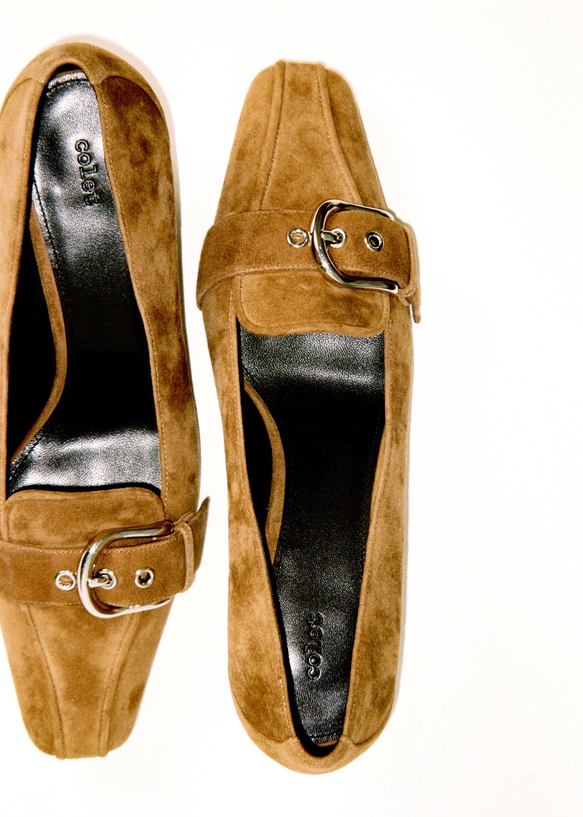 Pair of brown buckle flats viewed from above.