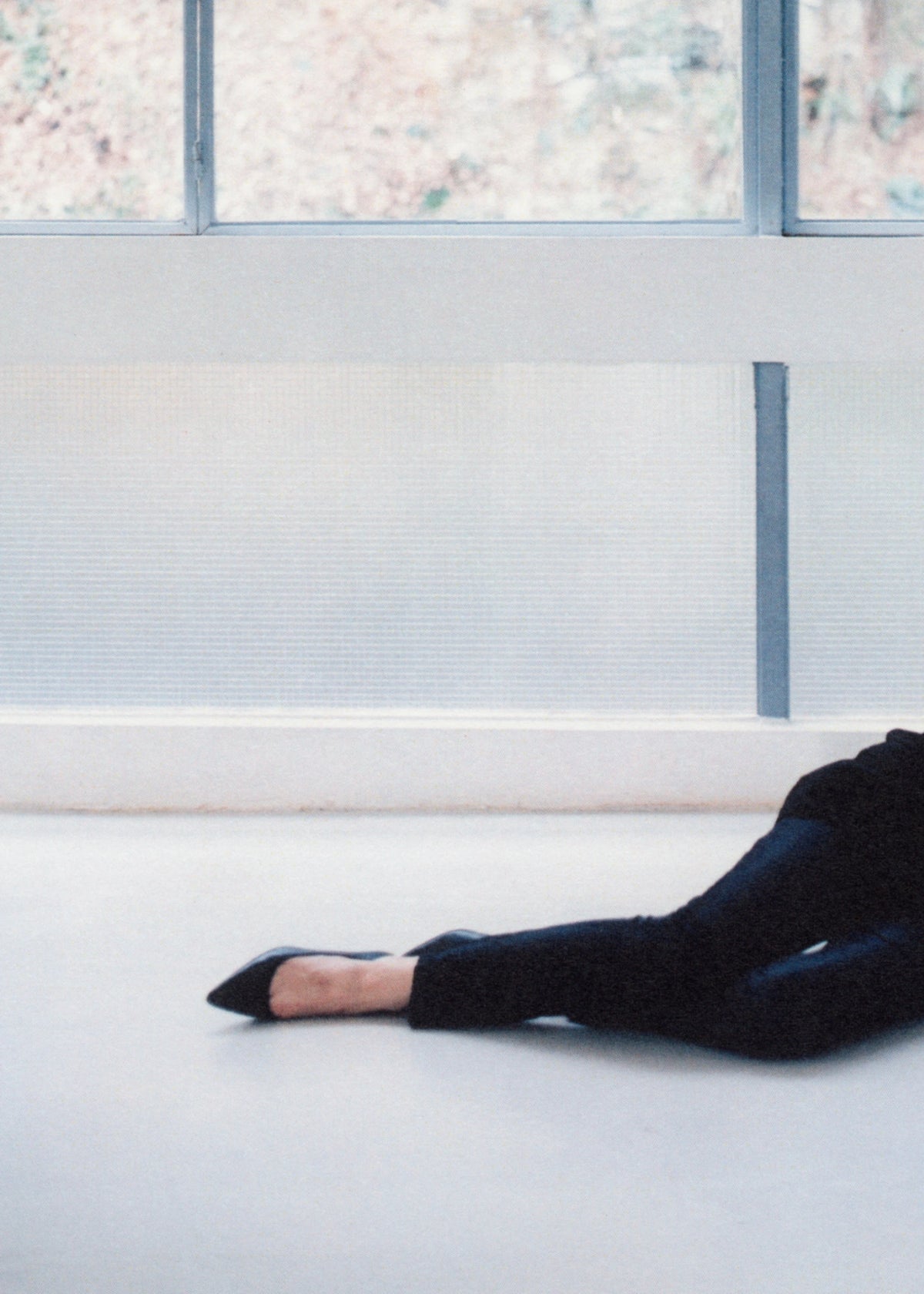 Cropped view of a reclining model beside a window.